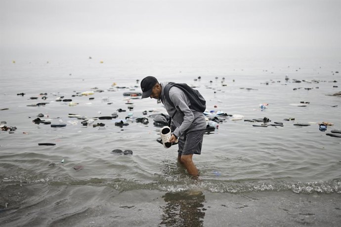 Un hombre recoge unas chanclas del agua, a 31 de julio de 2026, en Ceuta (España).  La ciudad autónoma de Ceuta ha amanecido con numerosas personas que seguían entrando desde Marruecos a primera hora de esta mañana después de una madrugada en la que la af