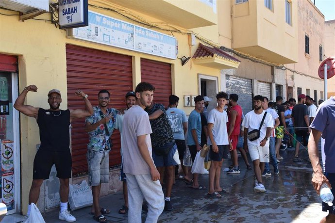 Varias personas hacen cola en un punto de atención humanitaria, a 5 de agosto de 2026, en Ceuta (España). Varias personas y agentes sociales, se han reunido en sedes y casas donde reparten comida, ropa y otros productos y dejan ducharse a las personas mig