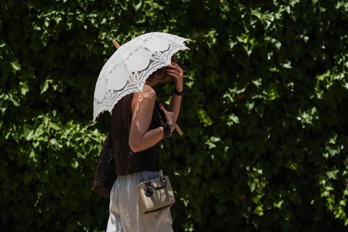 Archivo - Turistas se protegen del calor.