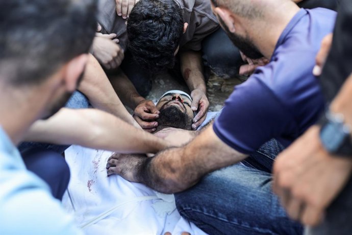 17 de julho de 2026, Territórios Palestinos, Nusairat: Palestinos choram diante do corpo de uma das vítimas mortas em um ataque aéreo israelense no campo de refugiados de Nuseirat. Um ataque aéreo israelense atingiu um grupo de palestinos no campo, matand