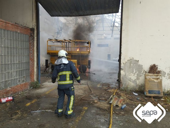 Efectivos de Bomberos sofocan el incendio en una nave en Castrillón.