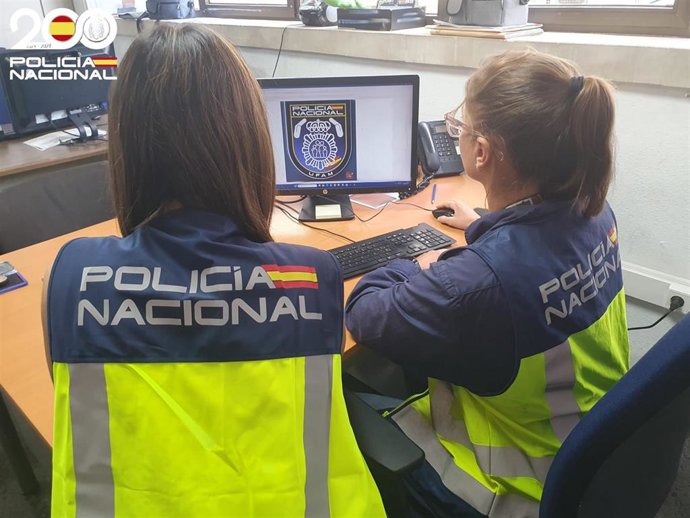 Dos agentes de la UFAM de la Policía Nacional, de espaldas.