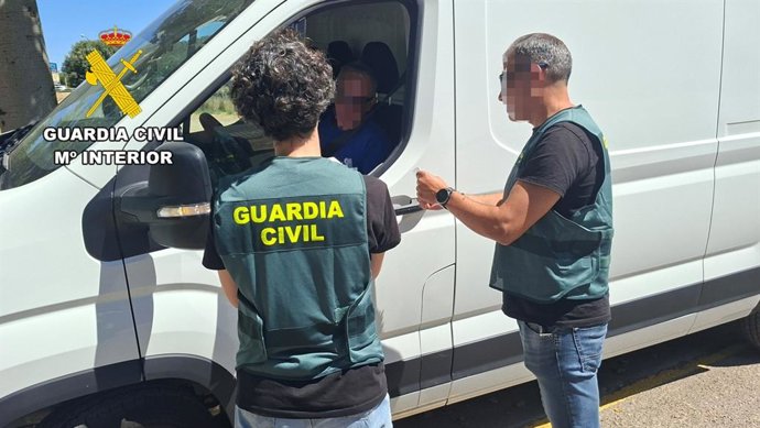 Agentes de la Guardia Civil, junto a una furgoneta de reparto.