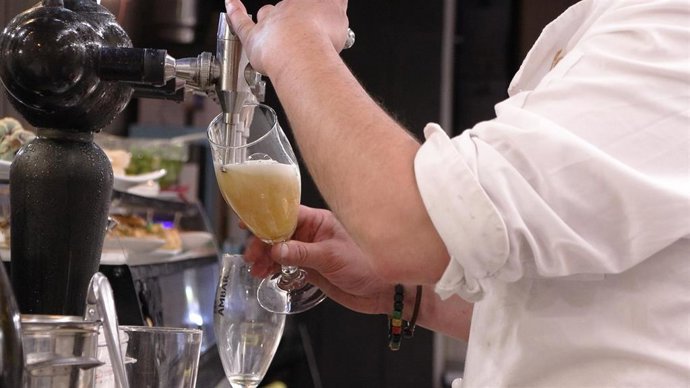 Archivo - Camarero en tirador de cerveza