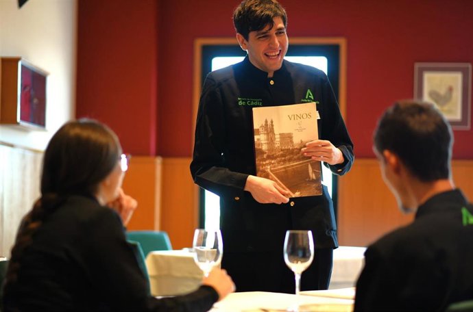Un alumno de la Escuela de Hostelería de Cádiz atendiendo en sala a unos comensales. ARCHIVO