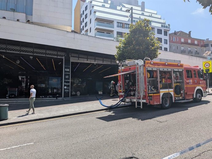 Bomberos trabajando en el incendio de una sidrería en el centro comercial El Vasco de Oviedo
