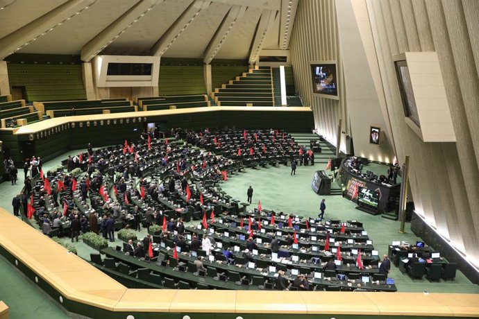 13 de julho de 2026, Teerã, Irã: Legisladores iranianos seguram bandeiras religiosas vermelhas durante uma sessão parlamentar em Teerã. Naquela noite, o parlamento do Irã realizou sua primeira sessão pública em mais de quatro meses, aprovando alterações r