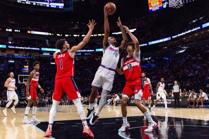 Archivo - April 13, 2025, Miami, Florida, United States: Miami Heat guard Josh Christopher (8) attempts to lay up the ball while defended by Washington Wizards forward Kyshawn George (18) and guard Colby Jones (1) during the first half of an NBA game at K