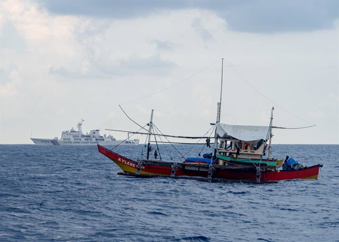 Archivo - Arquivo - 16 de maio de 2024, nas proximidades do Recife de Scarborough, Zambales, Filipinas: Um barco de pesca civil, o F/B Kylene (à frente), e a embarcação 4203 da Guarda Costeira da China, acompanhando-o durante a missão civil de reabastecim