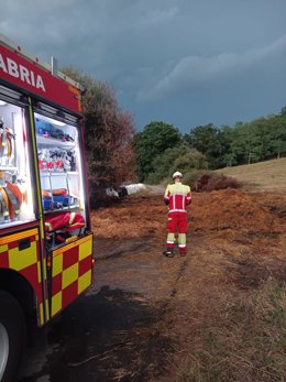 Un bombero sofoca un incendio declarado en unas pacas