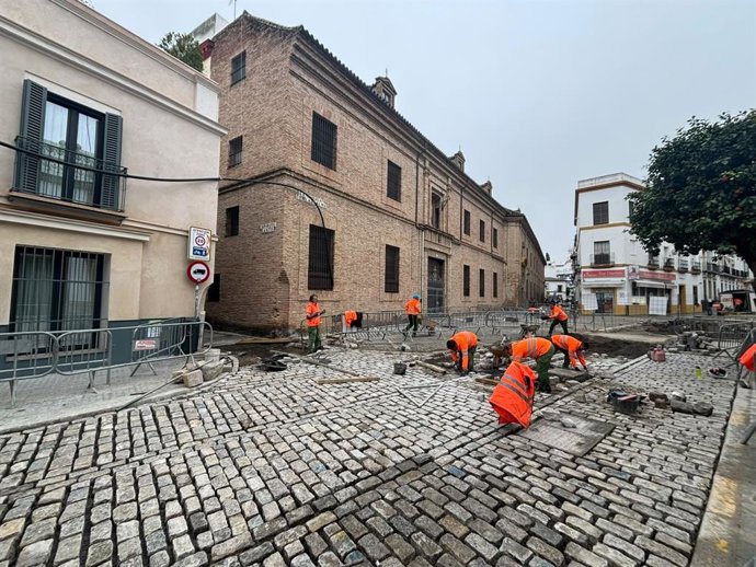 Imagen de trabajadores poniendo ladrillos en la vía.