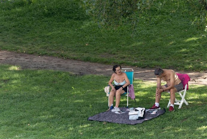 Personas afectadas por el calor pasean por Madrid Río, a 21 de julio de 2026, en Madrid (España). La Comunidad de Madrid ha activado el nivel 2 de "riesgo alto" por calor en la región ante una previsión de la Agencia Estatal de Meteorología (Aemet) para l