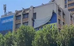 Trabalhadores retiram uma faixa de apoio à Ucrânia em Pristina (Kosovo)