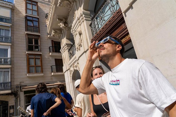 Un hombre prueba sus gafas homologadas para ver el eclipse en Cartagena
