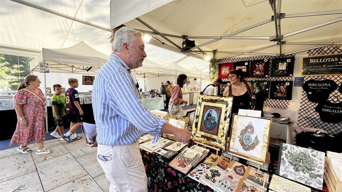 El edil Carlos Niño observa artículos de uno de los puestos de mercado.