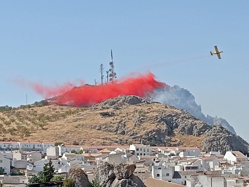 Un avión del Infoca realiza una descarga sobre las llamas en un pico situado junto a la localidad de Luque.