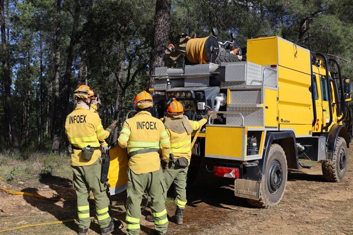 Archivo - Bomberos forestales junto a un camión del Infoex. Archivo.