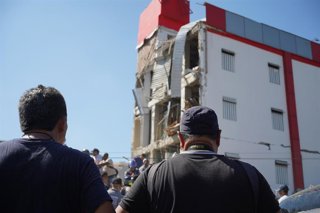 Varias personas se congregan entre los escombros de un edificio derrumbado para buscar supervivientes en Cali, Colombia, tras el terremoto de 7.4