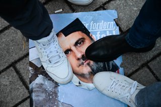 Archivo - 19 January 2026, Berlin: Participants stand over a picture of Ahmed al-Sharaa and former Syrian President Bashar al-Assad during a demonstration with the slogan "No welcome for Islamist Ahmed al-Sharaa in Berlin" against the visit of the Syrian 