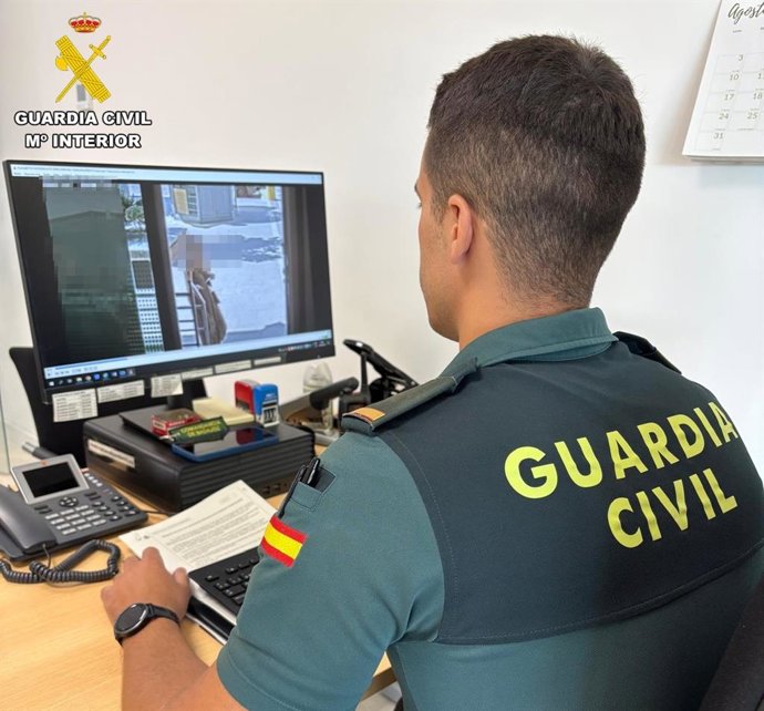 Un agente de la Guardia Cicil analiza las cámaras de seguridad del banco para comprobar la identidad de la persona que retiraba el dinero con la cartilla de la septuagenaria.