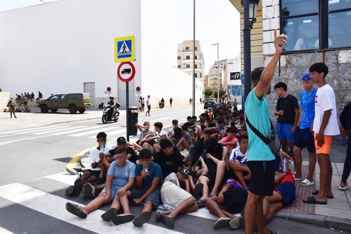 Un grupo de menores espera para ser filiado en una comisaría de la Policía Nacional, a 10 de agosto de 2026, en Ceuta (España). La ciudad acoge a miles de personas pendientes de retorno, entre ellas más de 1.300 menores, mientras las convocatorias difundi