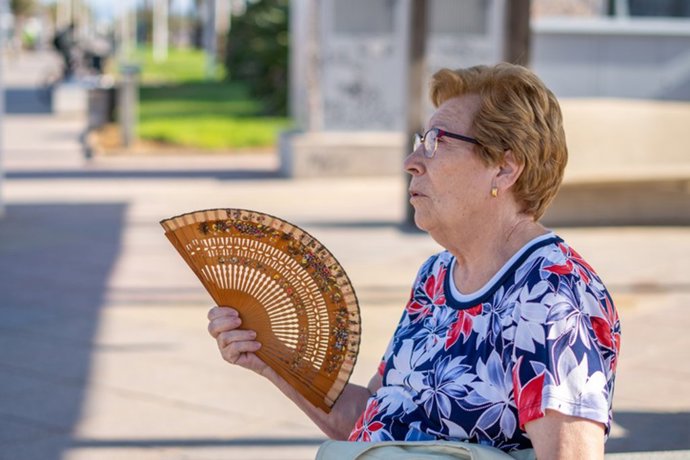 Archivo - Una mujer combate el calor con un abanico.