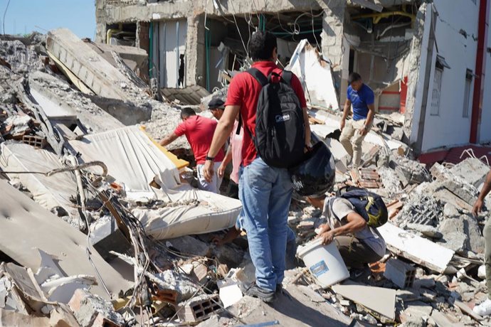 August 10, 2026, Cali, Valle Del Cauca, Colombia: People gather outside rubble of a collapsed building to search for survivors in Cali after a 7,4 Earthquake that struck Colombia on August 10, 2026.,Image: 1122112667, License: Rights-managed, Restrictions