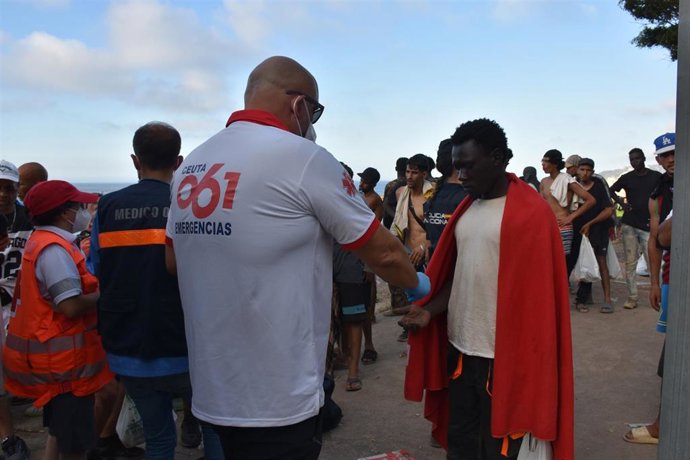 Cientos de personas migrantes reciben atención sanitaria de profesionales del INGESA y voluntarios de Cruz Roja, en la playa del Trampolín, a 7 de agosto de 2026, en Ceuta.