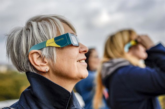 Archivo - Una mujer utiliza gafas homologadas para ver el eclipse. Imagen de archivo. 