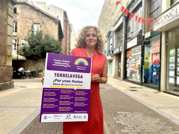 La concejala de Igualdad de Torrelavega, Patricia Portilla, sujeta el cartel de los Puntos Violeta y Arcoíris.