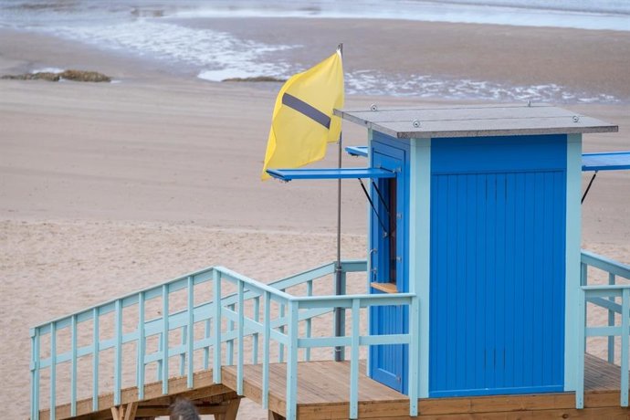 Archivo - Una bandera amarilla con el código ColorADD para daltónicos ondenando en una caseta de Socorrismo de una playa de Cádiz. ARCHIVO