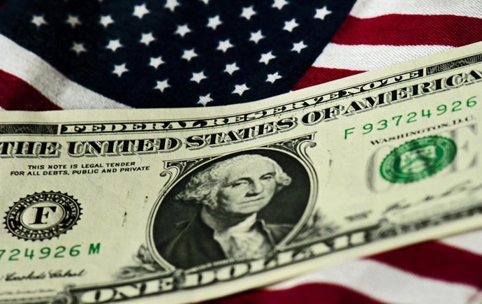 Archivo - Arquivo - ARQUIVADO - 14 de julho de 2011, Dresden: Uma nota de um dólar americano é retratada sobre uma bandeira dos EUA. Foto: Arno Burgi/dpa-Zentralbild/dpa