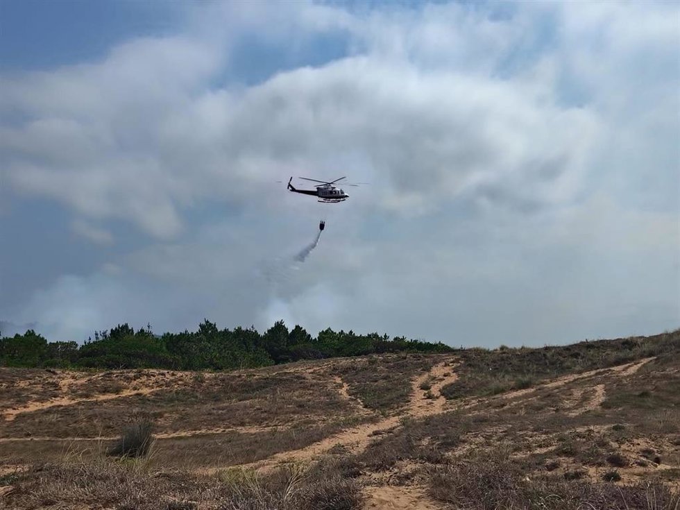 El helicóptero y bomberos del Gobierno cántabro trabajan en el incendio de los pinares de Liencres
