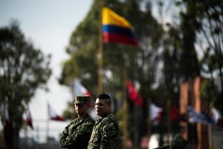 Archivo - Un soldado ondea la bandera de Colombia