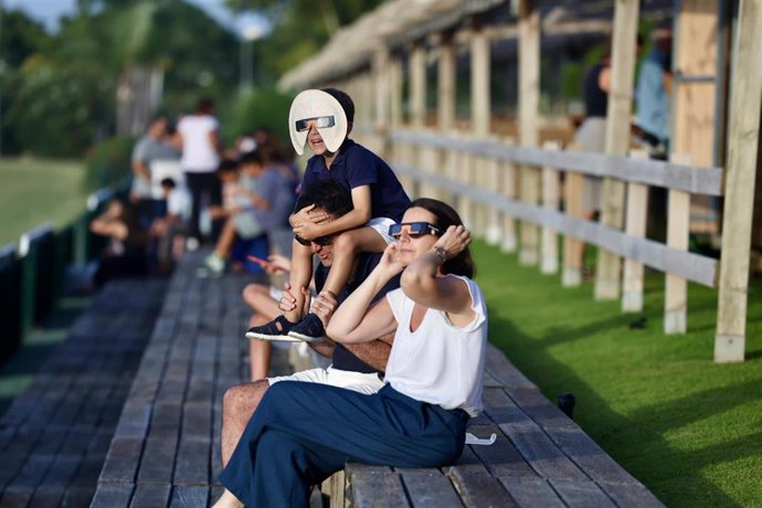 Una familia observa el eclipse solar.