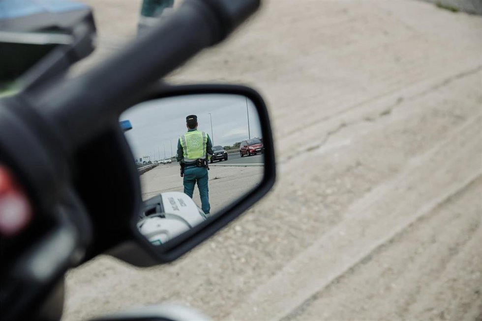 Archivo - Un agente de la Guardia Civil reflejado en el retrovisor de un vehículo