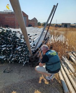 Un agente obserba tubos de regadío en una explotación agraria.