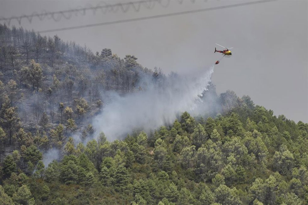 Un helicóptero bombardero trabaja en las tareas de extinción del incendio de Las Peñas de Riglos, a 11 de agosto de 2026, en Las Peñas de Riglos, Hoya de Huesca, Huesca, Aragón (España). El incendio forestal iniciado este lunes, 10 de agosto, en el términ