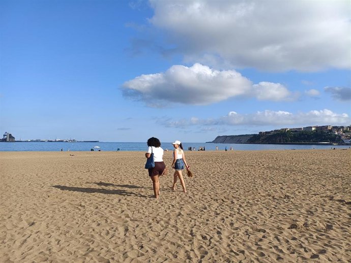 Archivo - Dos personas pasean en la playa