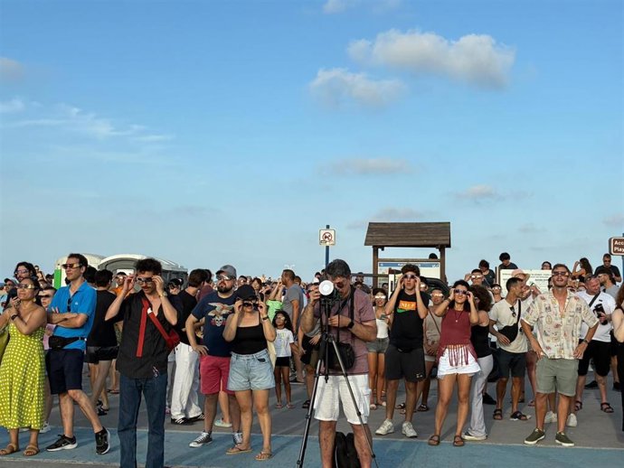 Personas contemplando el eclipse en la playa de la Malva-rosa