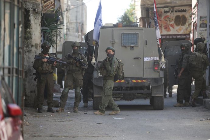 12 de agosto de 2026, Nablus, Palestina: Soldados israelenses assumem suas posições durante uma incursão no campo de refugiados de Balata, a leste de Nablus, na Cisjordânia. As forças militares israelenses invadiram o mercado central durante uma operação 