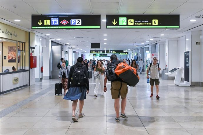 Varias personas en la zona de llegadas de la T2 del aeropuerto de Madrid.