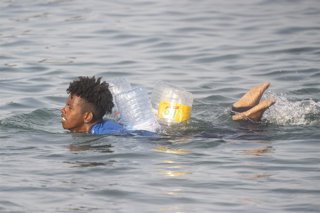 Un migrante intenta cruzar a España desde Marruecos, a 31 de julio de 2026, en Ceuta (España). 