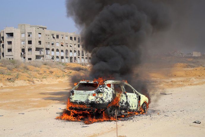 13 de agosto de 2026, Deir Al-Balah, Gaza, Território Palestino: Membros da Defesa Civil Palestina e palestinos deslocados trabalham para extinguir um incêndio em um carro após um ataque israelense na Rua Al-Rashid, a sudoeste da Cidade de Gaza, na Faixa 