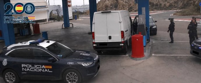 Agentes de la Policía Nacional junto a la furgoneta utilizada para el transporte de combustible en una gasolinera de Almería.