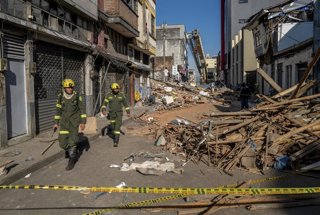 Los equipos de emergencia caminan por una calle repleta de escombros tras el terremoto del lunes en Pereira, Colombia, el martes 11 de agosto de 2026. 