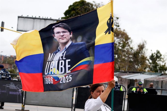 Archivo - Arquivo - 13 de agosto de 2025, Bogotá, Cundinamarca, Colômbia: Uma pessoa acena com uma bandeira colombiana com a foto de Miguel Uribe Turbay durante o funeral e o enterro do candidato à presidência Miguel Uribe Turbay, que foi vítima de dois t