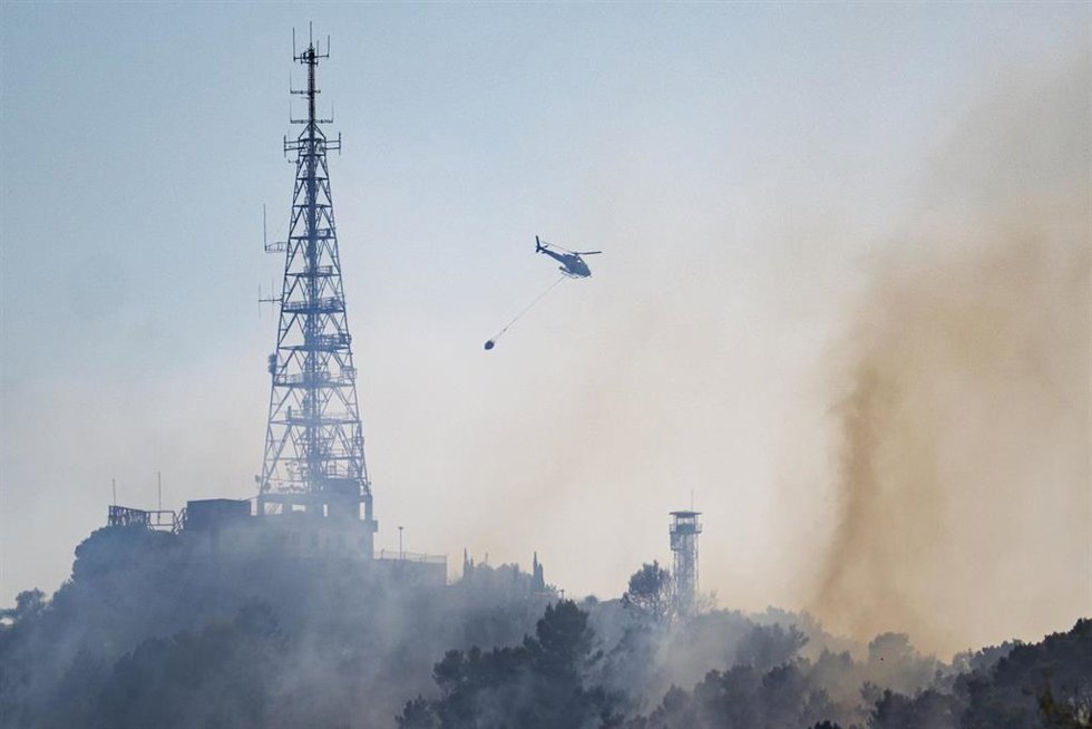 Un helicóptero trabaja en las labores de extinción de un fuego, a 14 de agosto de 2026, en Barcelona, Catalunya (España)