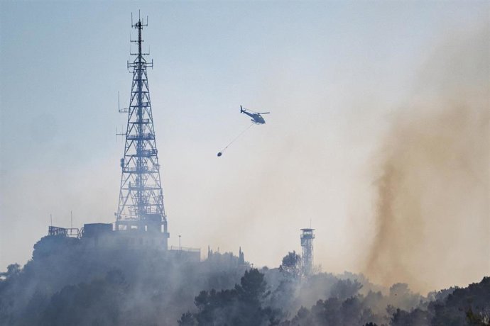 Un helicóptero trabaja en las labores de extinción de un fuego, a 14 de agosto de 2026, en Barcelona, Catalunya (España)
