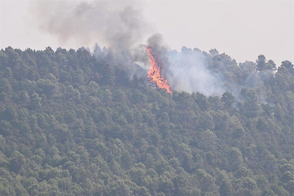 Llamas y humo durante las labores de extinción de un incendio forestal, a 14 de agosto de 2026, en Las Peñas de Riglos, Hoya de Huesca, Huesca, Aragón (España). El incendio declarado a las 12.37 de este lunes en las Peñas de Riglos (Huesca) ha calcinado y